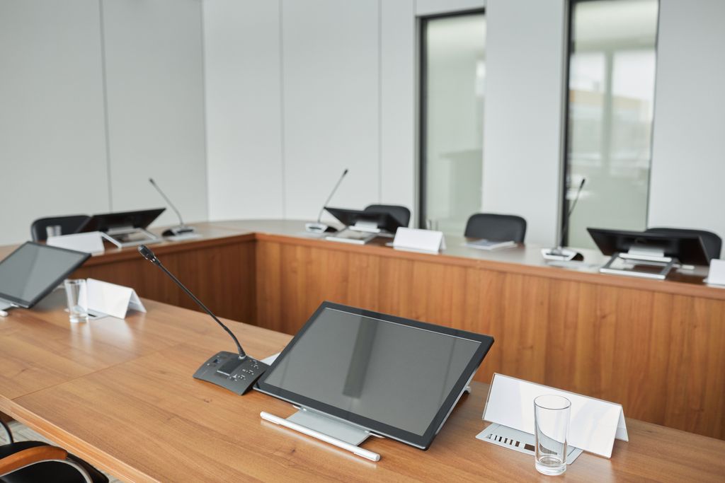 Spacious conference room equipped with modern technology and microphones for meetings.